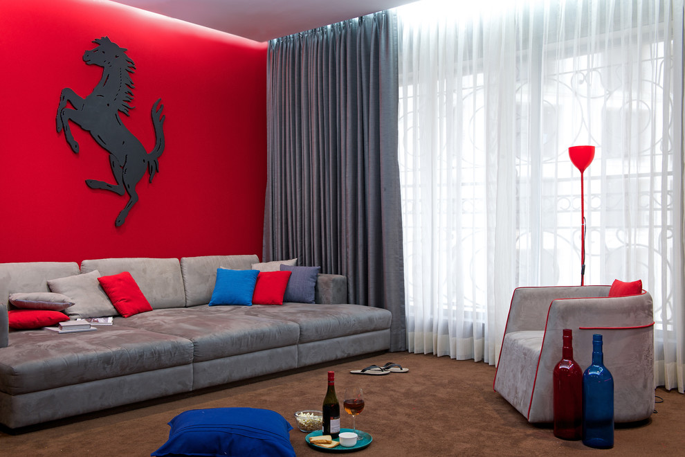 Mid-sized contemporary home theatre in Mumbai with red walls, carpet and brown floor.