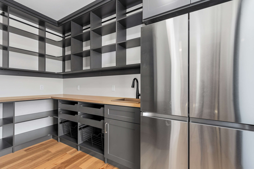 Inspiration for a mid-sized transitional single-wall medium tone wood floor, brown floor and tray ceiling eat-in kitchen remodel with an undermount sink, shaker cabinets, white cabinets, quartz countertops, white backsplash, quartz backsplash, stainless steel appliances, an island and white countertops