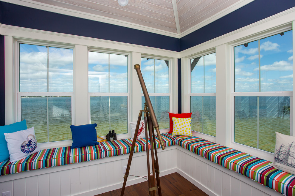 Large beach style sunroom with dark hardwood floors, no fireplace and a standard ceiling.