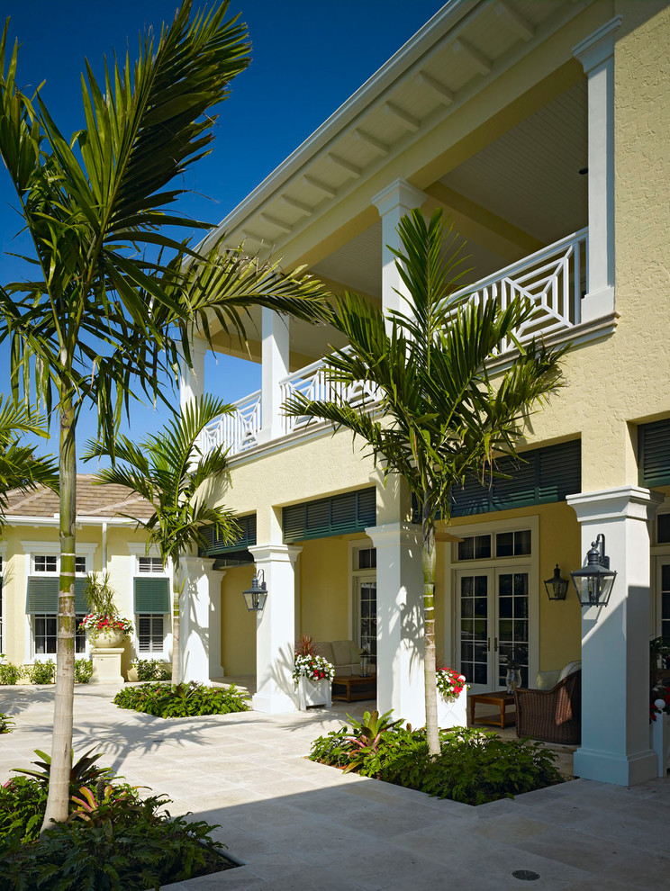 This is an example of a tropical yellow exterior in Miami.