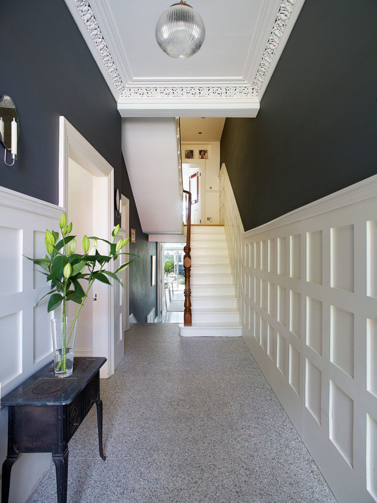 This is an example of a mid-sized traditional entry hall in Dublin with grey walls, granite floors and a single front door.