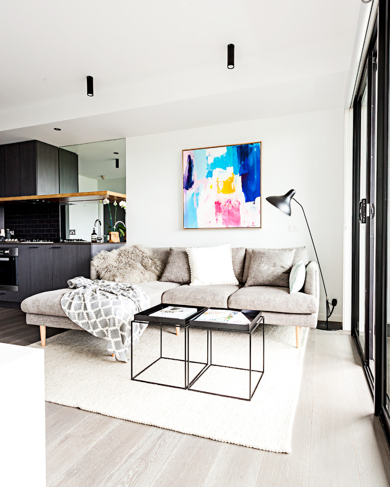 Small contemporary living room in Melbourne with white walls and medium hardwood floors.
