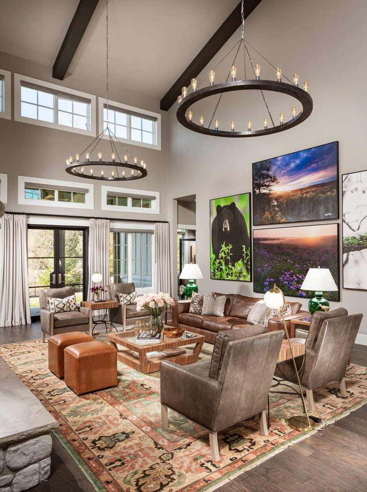 This is an example of an expansive transitional formal open concept living room in Other with grey walls, a stone fireplace surround, brown floor and medium hardwood floors.