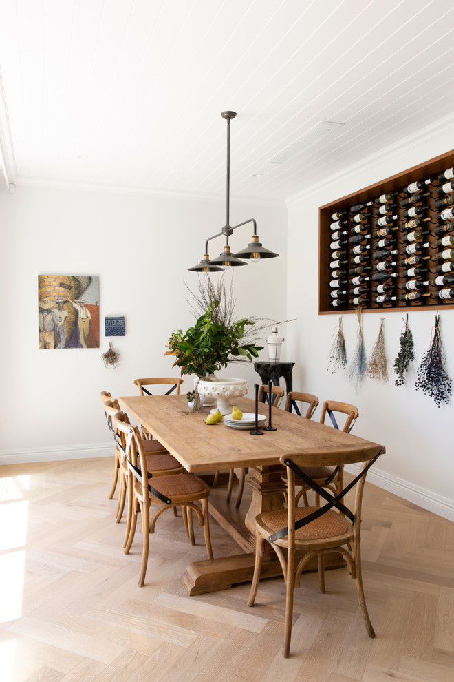 This is an example of a transitional separate dining room in Melbourne with white walls, light hardwood floors and beige floor.