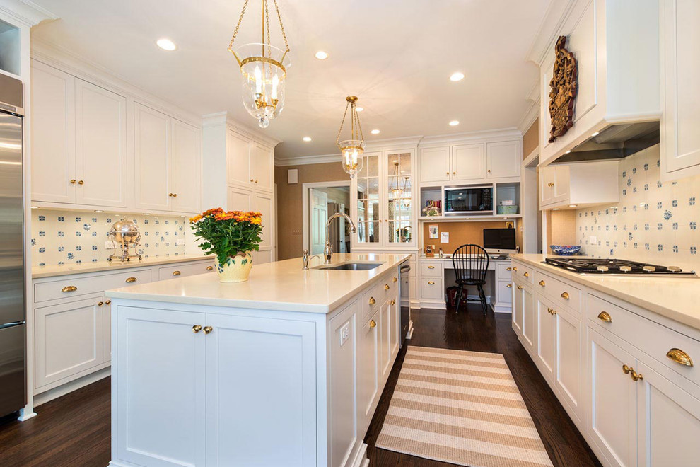 Example of a mid-sized transitional galley dark wood floor and brown floor eat-in kitchen design in Chicago with an undermount sink, recessed-panel cabinets, stainless steel appliances, an island, white cabinets, solid surface countertops, white backsplash and ceramic backsplash