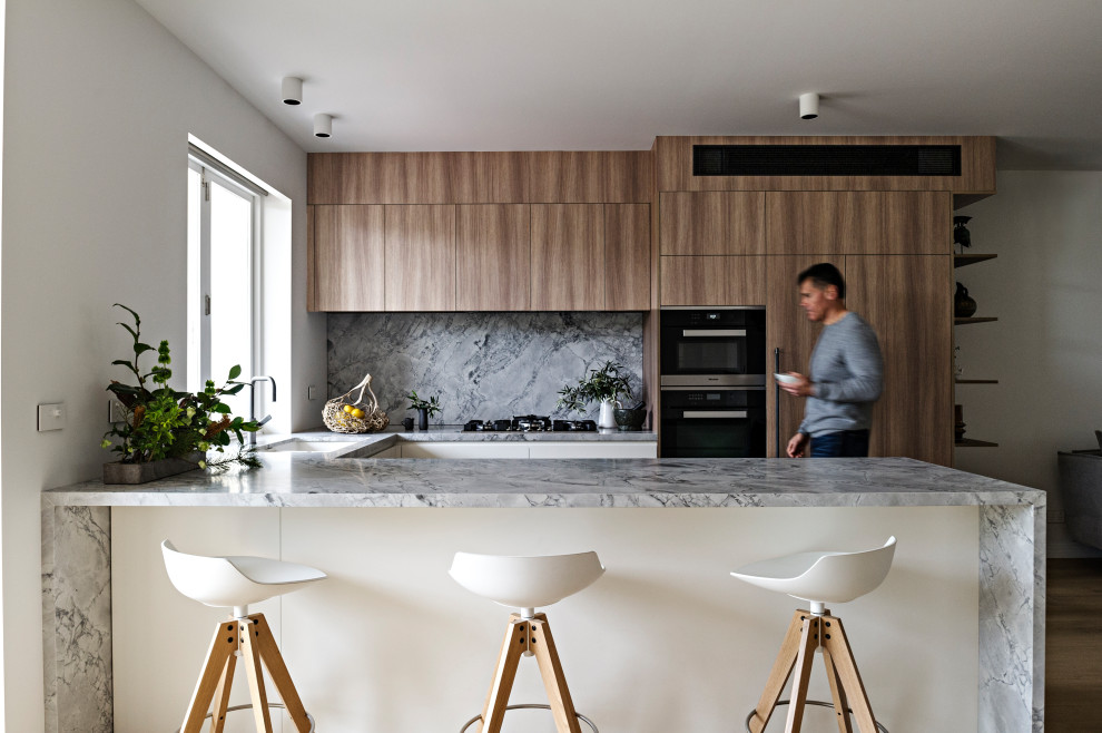 This is an example of a mid-sized contemporary u-shaped eat-in kitchen in Melbourne with white cabinets.
