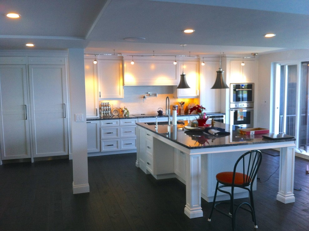 Large transitional single-wall dark wood floor and brown floor open concept kitchen photo in Miami with a single-bowl sink, shaker cabinets, white cabinets, granite countertops, white backsplash, stone tile backsplash, stainless steel appliances and an island