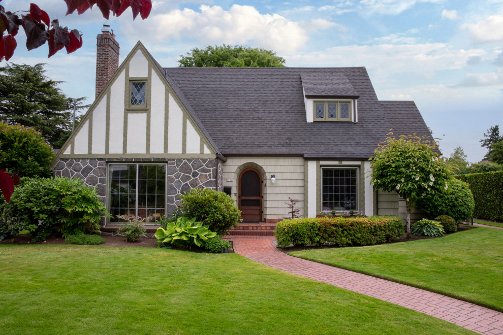 Large transitional green house exterior in Portland with stone veneer and shingle siding.