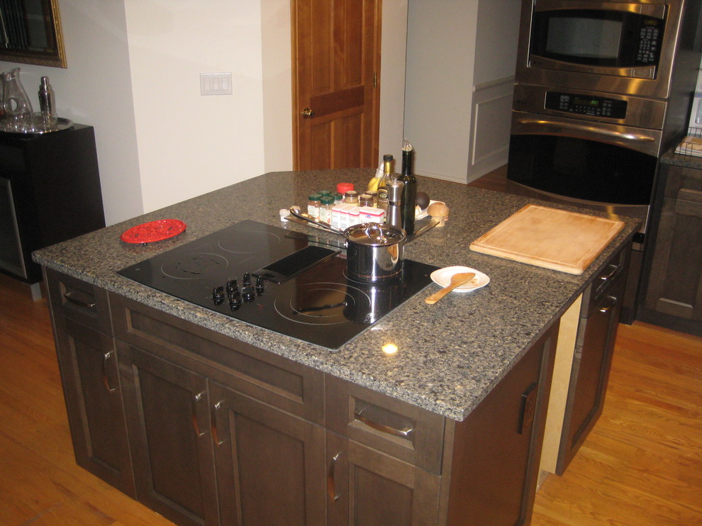 Example of a transitional medium tone wood floor kitchen design in Seattle with an undermount sink, gray cabinets and stainless steel appliances