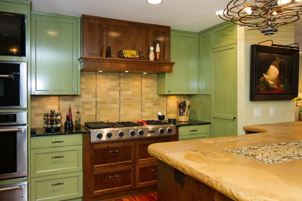 Photo of a large traditional u-shaped eat-in kitchen in Minneapolis with green cabinets, stainless steel appliances, with island, an undermount sink, recessed-panel cabinets, soapstone benchtops, beige splashback, ceramic splashback and medium hardwood floors.