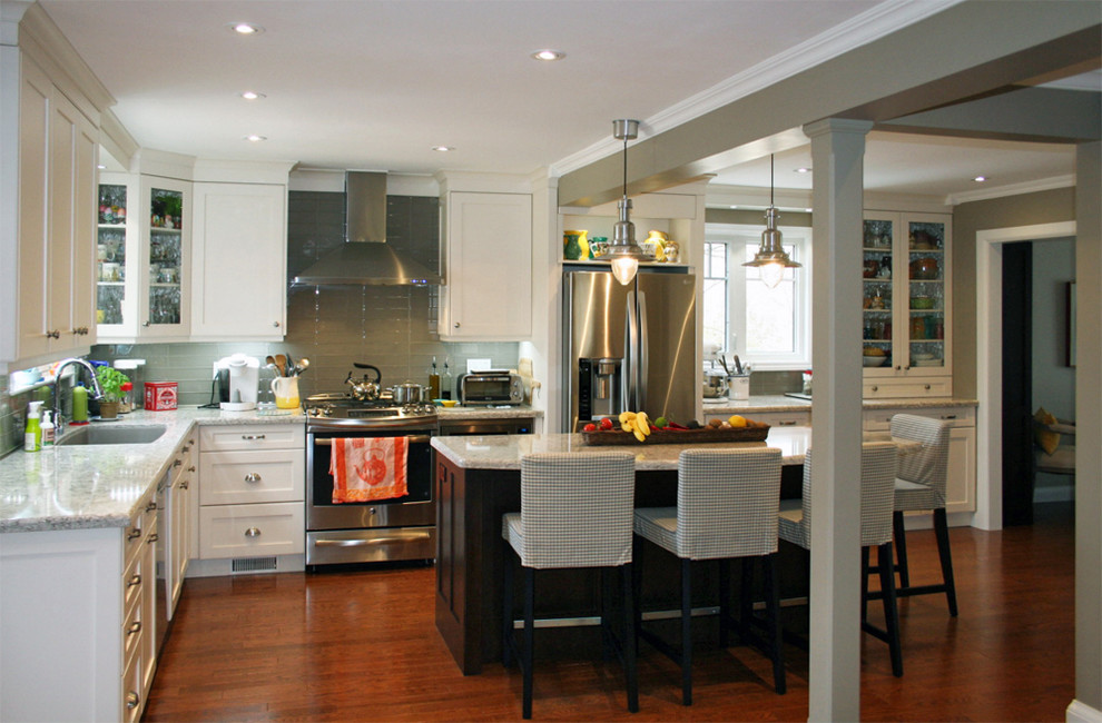 Eat-in kitchen - large transitional l-shaped medium tone wood floor eat-in kitchen idea in Toronto with an undermount sink, shaker cabinets, white cabinets, quartz countertops, gray backsplash, glass tile backsplash, stainless steel appliances and an island