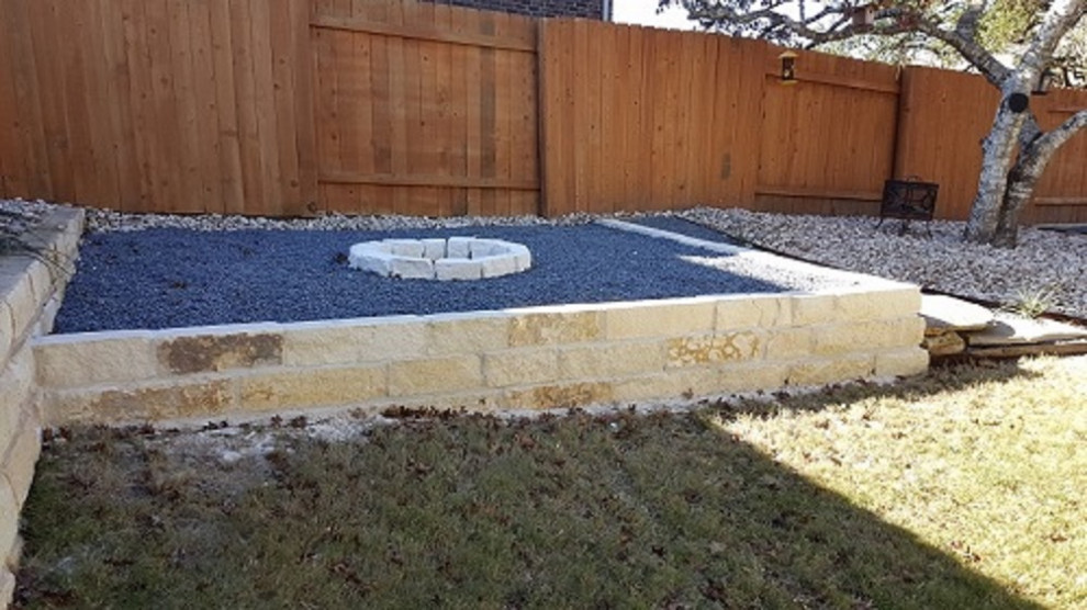 Photo of a large contemporary backyard partial sun xeriscape in Austin with a fire feature and river rock.