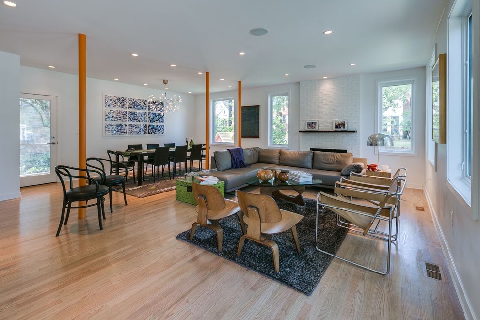 Contemporary open concept living room in DC Metro with white walls, light hardwood floors and beige floor.