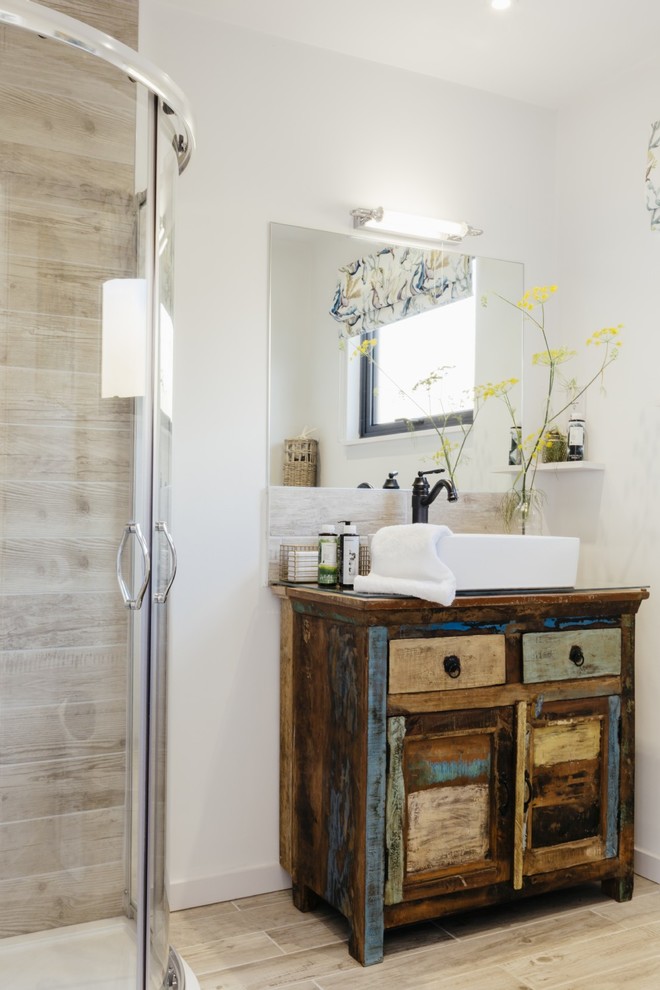 Photo of a small contemporary bathroom in Cornwall with shaker cabinets, distressed cabinets, a corner shower, beige tile, ceramic tile, white walls, light hardwood floors, a trough sink, wood benchtops, beige floor and a sliding shower screen.