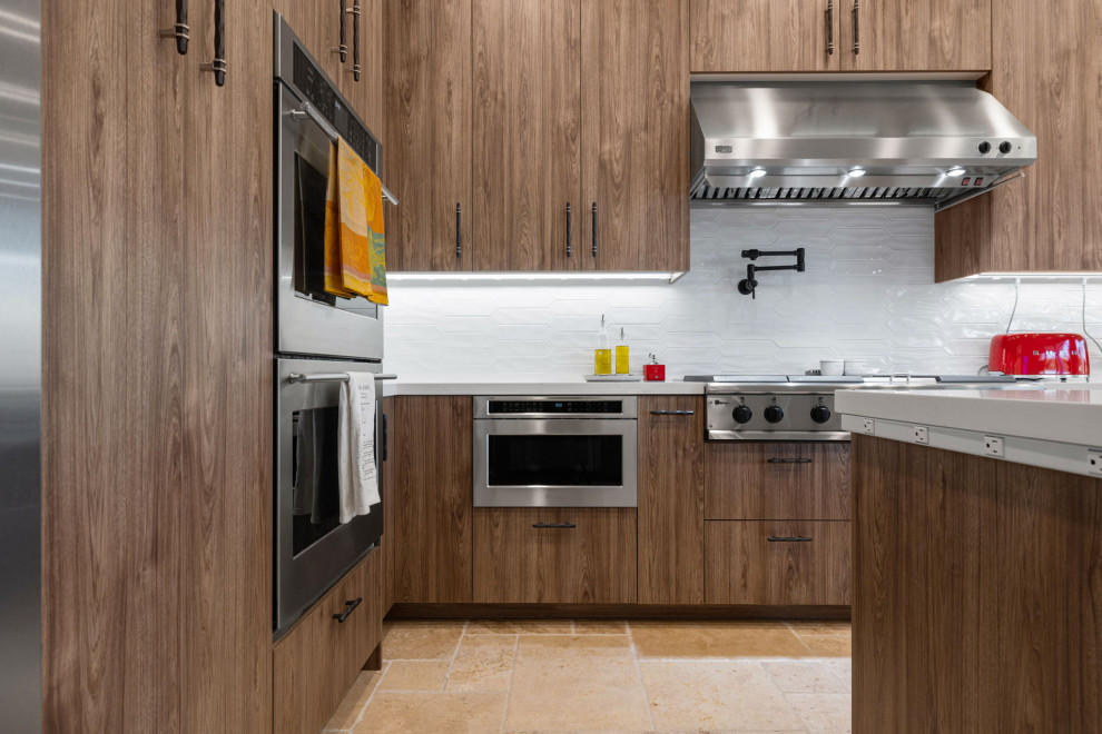 Example of a mountain style l-shaped slate floor and beige floor enclosed kitchen design with a single-bowl sink, flat-panel cabinets, medium tone wood cabinets, quartzite countertops, white backsplash, glass sheet backsplash, stainless steel appliances, a peninsula and white countertops