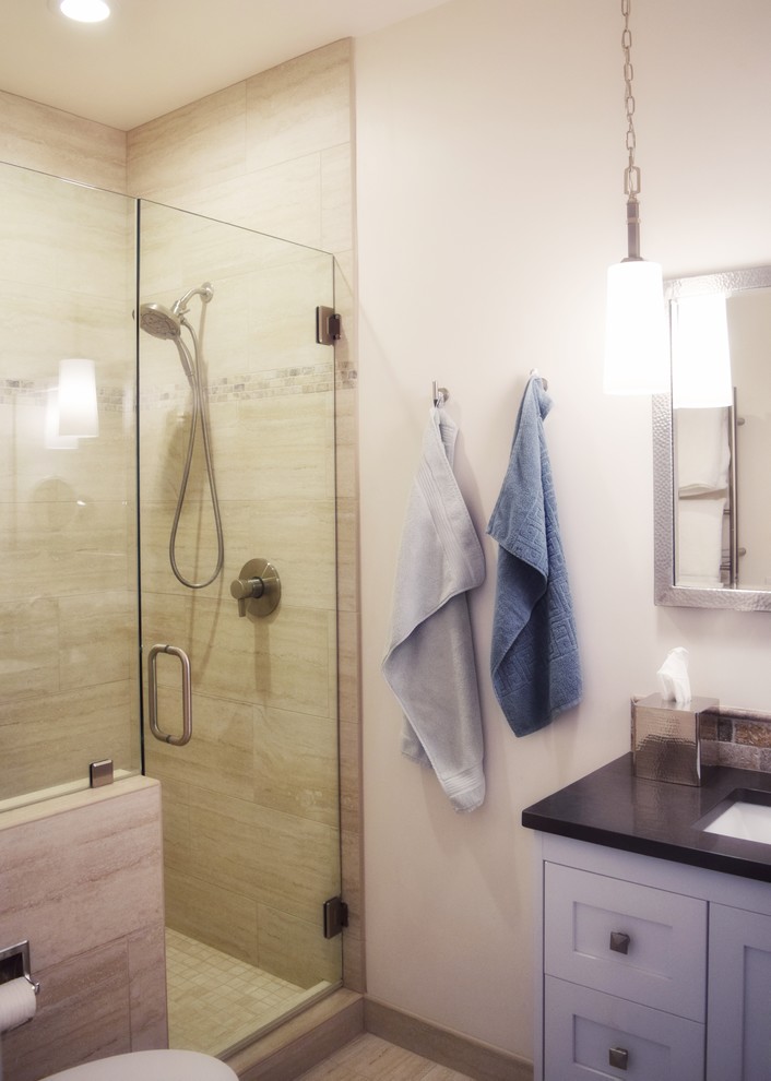 Photo of a small beach style bathroom in Santa Barbara with shaker cabinets, white cabinets, an alcove shower, a one-piece toilet, beige tile, ceramic tile, yellow walls, ceramic floors, an undermount sink, engineered quartz benchtops, beige floor and a hinged shower door.
