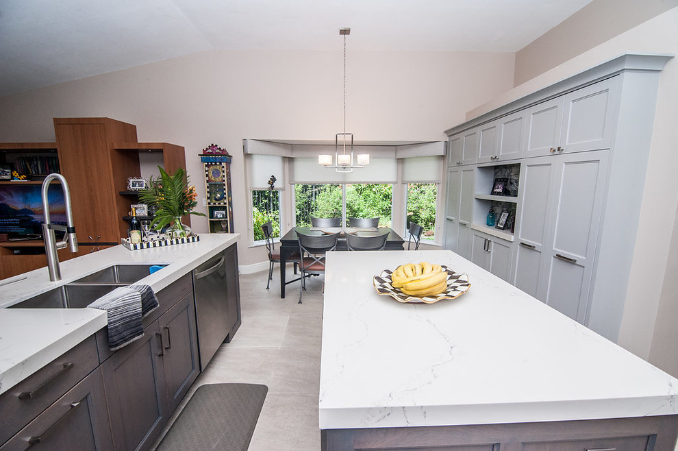 Inspiration for a mid-sized transitional u-shaped porcelain tile and beige floor eat-in kitchen remodel in Miami with an undermount sink, shaker cabinets, gray cabinets, quartz countertops, gray backsplash, glass tile backsplash, stainless steel appliances, white countertops and an island