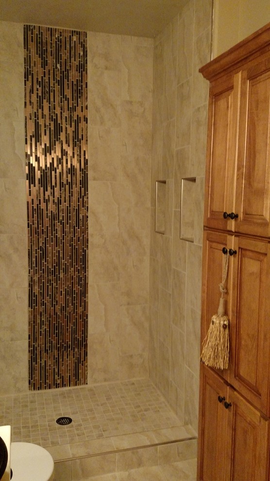Small transitional master ceramic tile and beige floor alcove shower photo with raised-panel cabinets, medium tone wood cabinets, a two-piece toilet, brown walls, a vessel sink and solid surface countertops