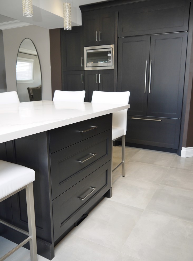Inspiration for a mid-sized transitional l-shaped porcelain tile and gray floor eat-in kitchen remodel in Toronto with an undermount sink, recessed-panel cabinets, dark wood cabinets, quartz countertops, white backsplash, marble backsplash, stainless steel appliances, an island and white countertops