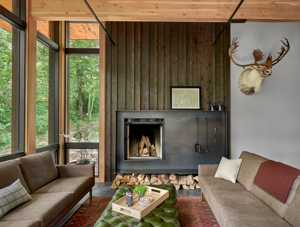 Lawless Retreat - A sense of craft, texture and color mark this living room.  Charred cedar surrounds the blackened steel fireplace. Together they anchor the living room which otherwise is open to the views beyond.
