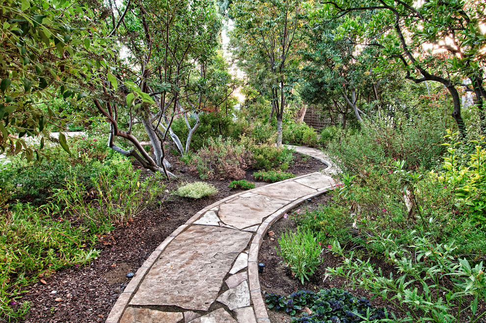 Inspiration for a mediterranean backyard garden in Orange County with natural stone pavers.