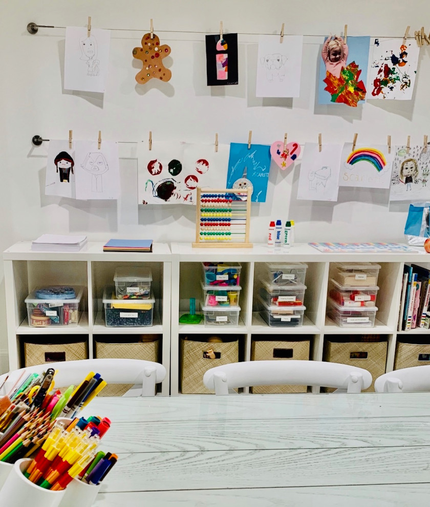 Photo of a mid-sized traditional gender-neutral kids' playroom for kids 4-10 years old in New York with white walls, laminate floors, grey floor, coffered and wood walls.