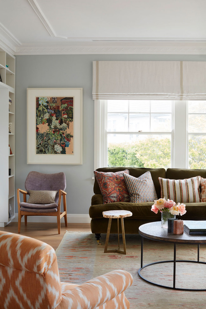 Großes, Fernseherloses, Offenes Eklektisches Wohnzimmer mit blauer Wandfarbe, braunem Holzboden, Kamin, gefliester Kaminumrandung und braunem Boden in Sydney