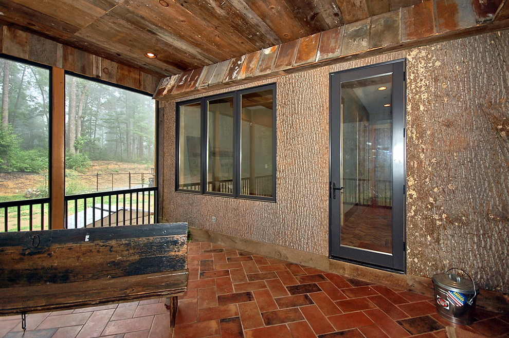 Large mountain style tile screened-in back porch photo with a roof extension