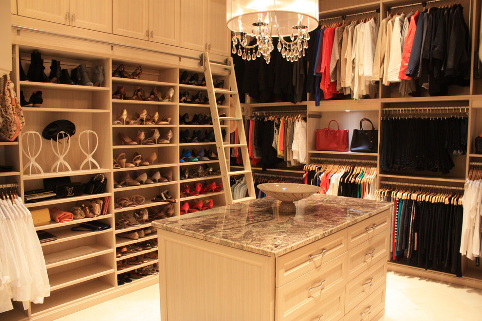 This is an example of a large traditional gender-neutral walk-in wardrobe in Miami with recessed-panel cabinets and beige cabinets.