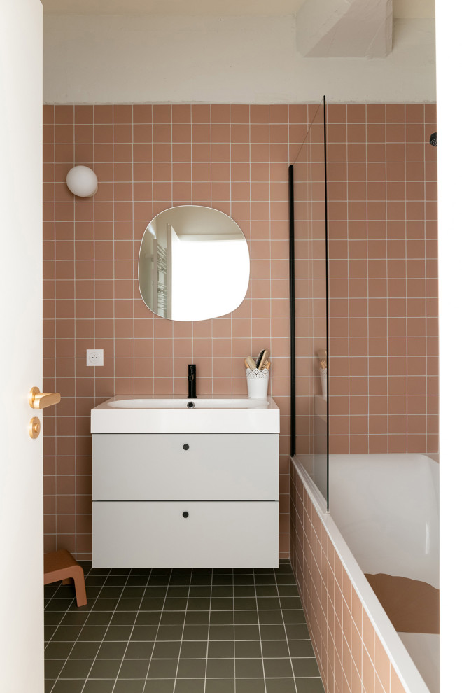 На фото: ванная комната с фасадами с декоративным кантом, серыми фасадами, полновстраиваемой ванной, розовой плиткой, керамической плиткой, розовыми стенами, полом из керамической плитки, зеленым полом, тумбой под одну раковину и подвесной тумбой