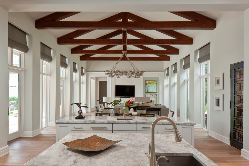 Inspiration for a large galley light wood floor eat-in kitchen remodel in Miami with an integrated sink, recessed-panel cabinets, white cabinets, white backsplash, stainless steel appliances and an island