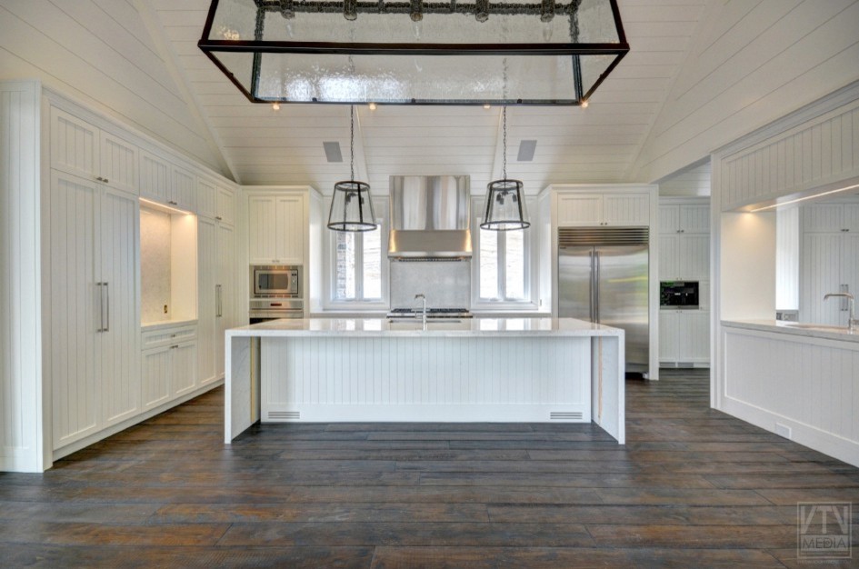 Inspiration for a mid-sized rustic brown floor eat-in kitchen remodel in Toronto with white cabinets, stainless steel appliances and an island