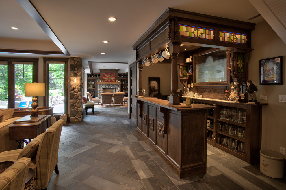 Inspiration for a large country galley home bar in Minneapolis with open cabinets, medium wood cabinets, wood benchtops, slate floors, grey floor and brown benchtop.