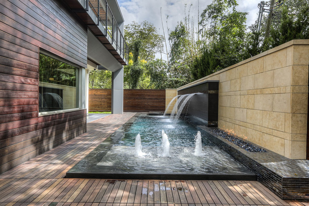 Inspiration for a small modern backyard deck in Houston with a water feature.