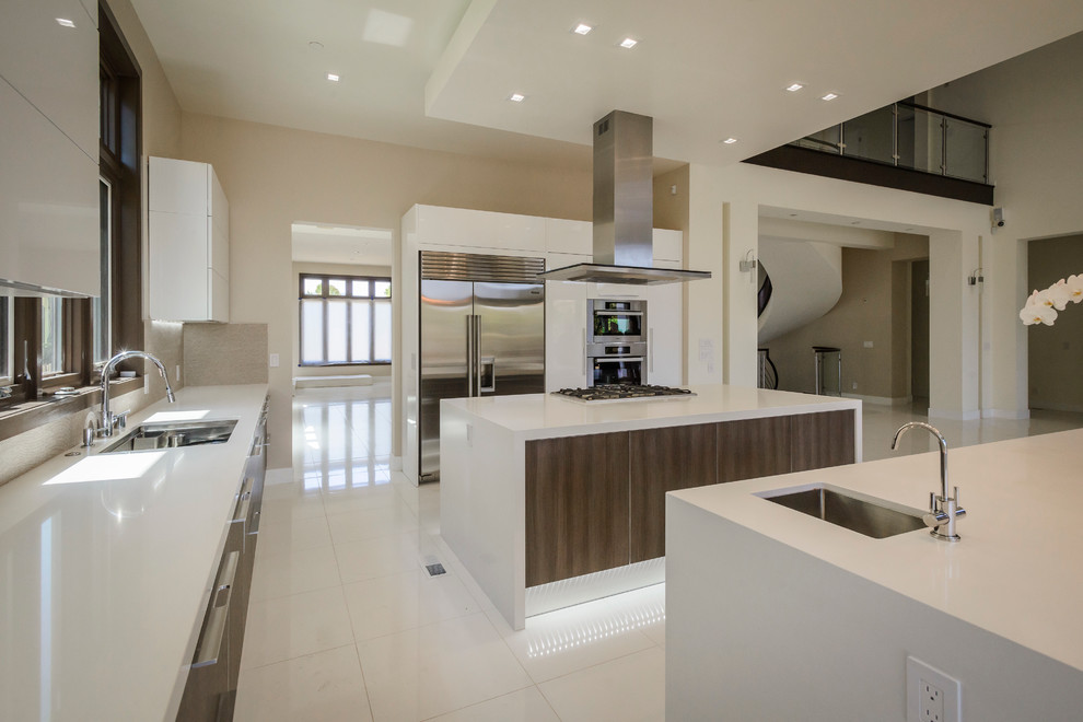 Inspiration for an expansive contemporary l-shaped open plan kitchen in San Francisco with an integrated sink, flat-panel cabinets, white cabinets, quartz benchtops, stainless steel appliances and multiple islands.