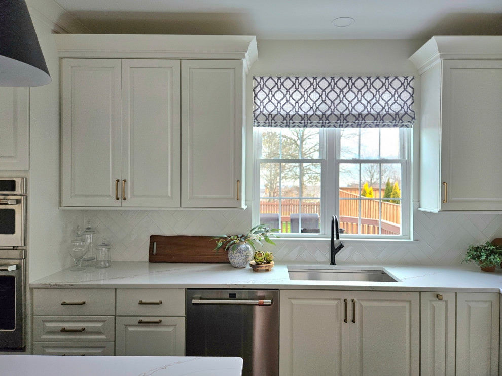 Example of a large transitional u-shaped medium tone wood floor eat-in kitchen design in DC Metro with an undermount sink, raised-panel cabinets, white cabinets, quartz countertops, white backsplash, ceramic backsplash, stainless steel appliances, an island and white countertops