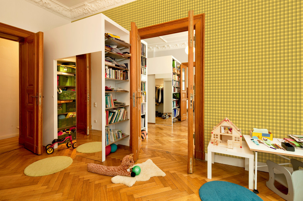 This is an example of a large traditional kids' playroom for kids 4-10 years old and boys in Berlin with dark hardwood floors and multi-coloured walls.