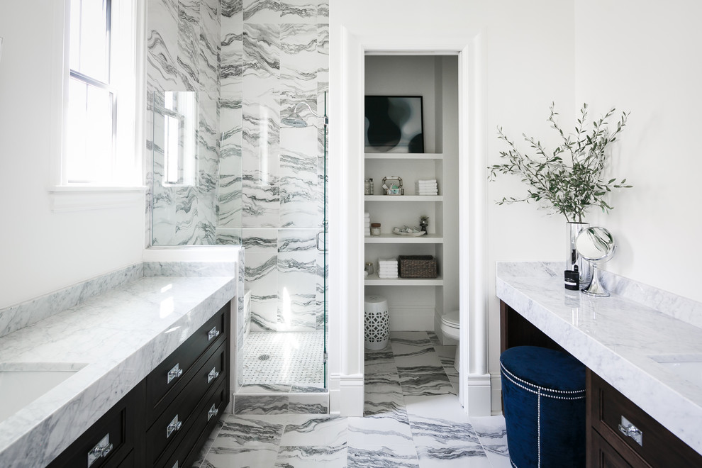 This is an example of a mid-sized transitional master bathroom in Louisville with dark wood cabinets, an alcove shower, a two-piece toilet, white tile, porcelain tile, white walls, porcelain floors, an undermount sink, marble benchtops, white floor, a hinged shower door and recessed-panel cabinets.