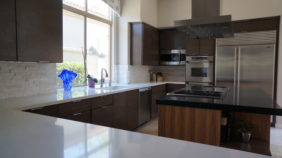 Mid-sized transitional u-shaped travertine floor and beige floor open concept kitchen photo in Phoenix with a single-bowl sink, flat-panel cabinets, dark wood cabinets, quartz countertops, white backsplash, stone tile backsplash, stainless steel appliances and an island