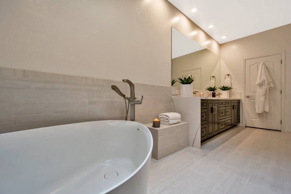 Large contemporary master bathroom in Phoenix with raised-panel cabinets, black cabinets, a freestanding tub, an open shower, gray tile, porcelain tile, grey walls, porcelain floors, an undermount sink, engineered quartz benchtops, grey floor, an open shower and white benchtops.