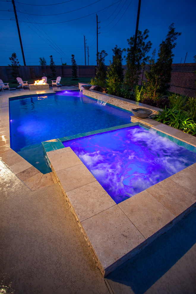 This is an example of a large arts and crafts backyard rectangular pool in Houston with a hot tub and decking.