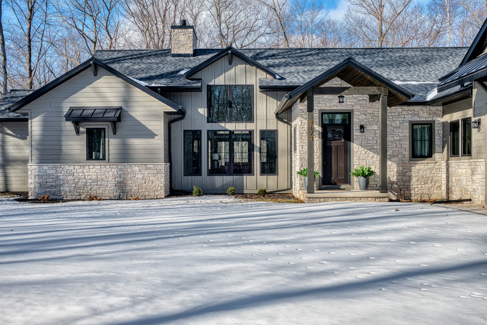 Large transitional gray one-story mixed siding and clapboard gable roof idea with a mixed material roof and a black roof