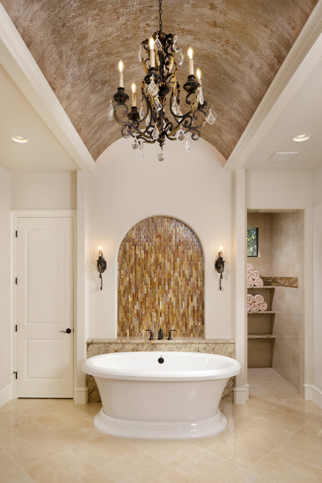 Inspiration for a large mediterranean master bathroom in Houston with a freestanding tub, an open shower, a one-piece toilet, beige tile, mosaic tile, beige walls, porcelain floors, beige floor and an open shower.