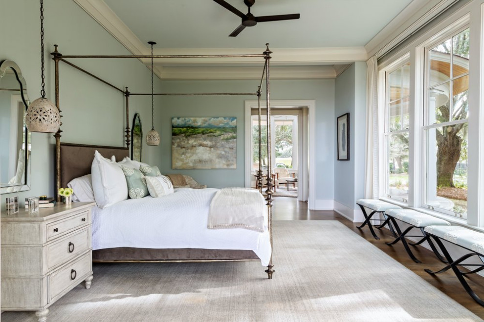 Photo of a large beach style master bedroom in Charleston with blue walls, medium hardwood floors, no fireplace and brown floor.