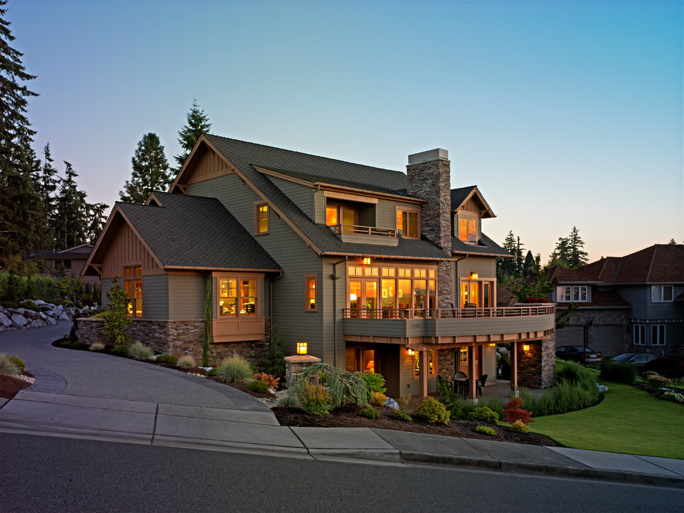 Large arts and crafts three-storey green house exterior in Seattle with mixed siding, a gable roof and a shingle roof.