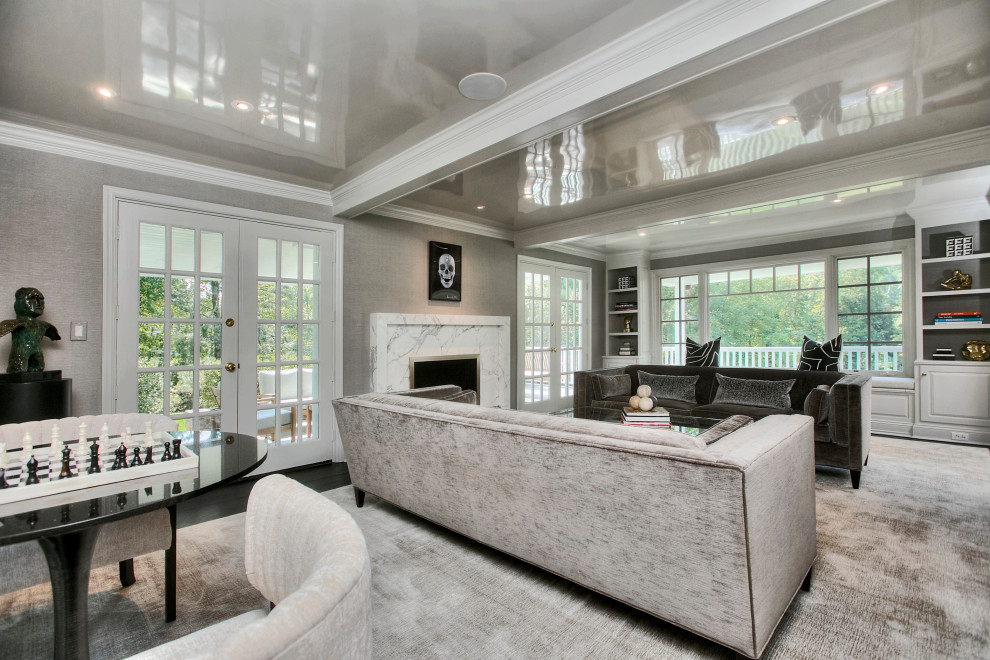 Large transitional enclosed living room in New York with grey walls, dark hardwood floors, a standard fireplace, a stone fireplace surround, no tv and black floor.