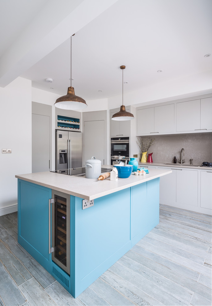 This is an example of a mid-sized contemporary u-shaped open plan kitchen in London with a double-bowl sink, flat-panel cabinets, quartz benchtops, stone slab splashback, stainless steel appliances, porcelain floors, with island, grey floor and grey cabinets.