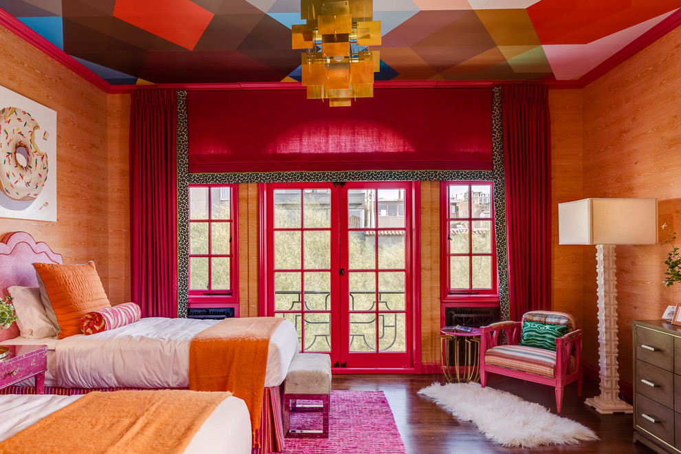 This is an example of an eclectic bedroom in New York with orange walls and dark hardwood floors.