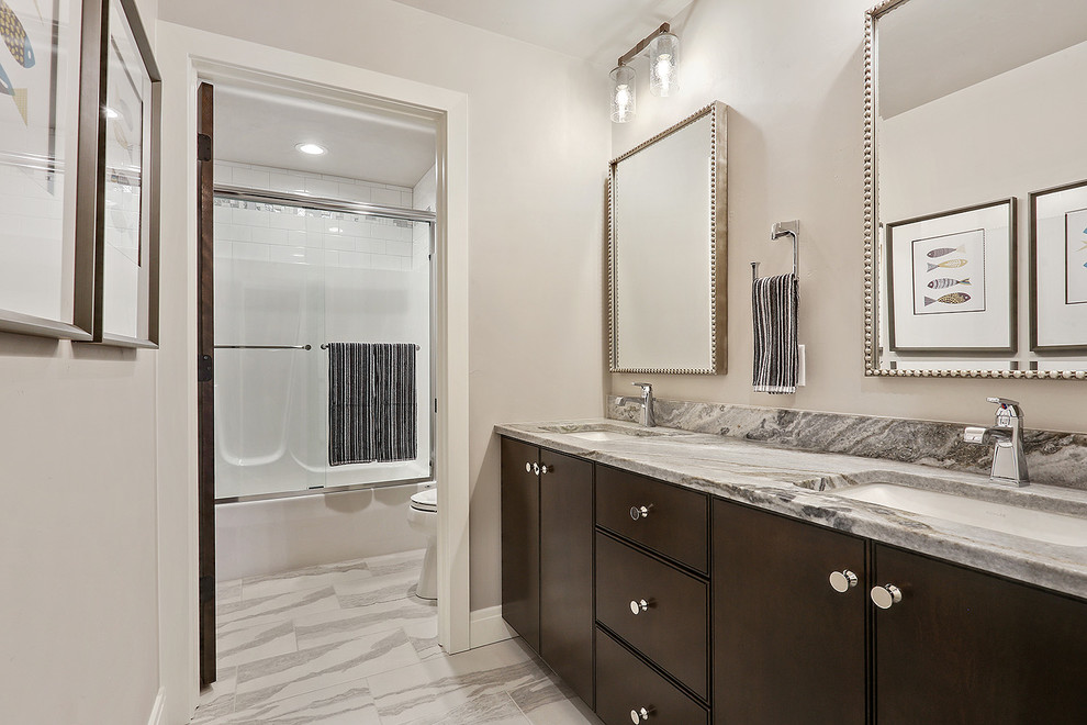 Design ideas for a large beach style kids bathroom in Other with flat-panel cabinets, brown cabinets, an alcove tub, a shower/bathtub combo, a two-piece toilet, grey walls, ceramic floors, an undermount sink, marble benchtops, white floor, a sliding shower screen and blue benchtops.