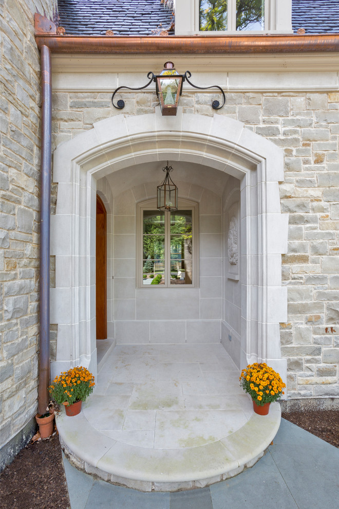 Photo of a large eclectic two-storey grey house exterior in Chicago with stone veneer.